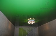 Натяжной потолок глянцевый зеленый в спальне